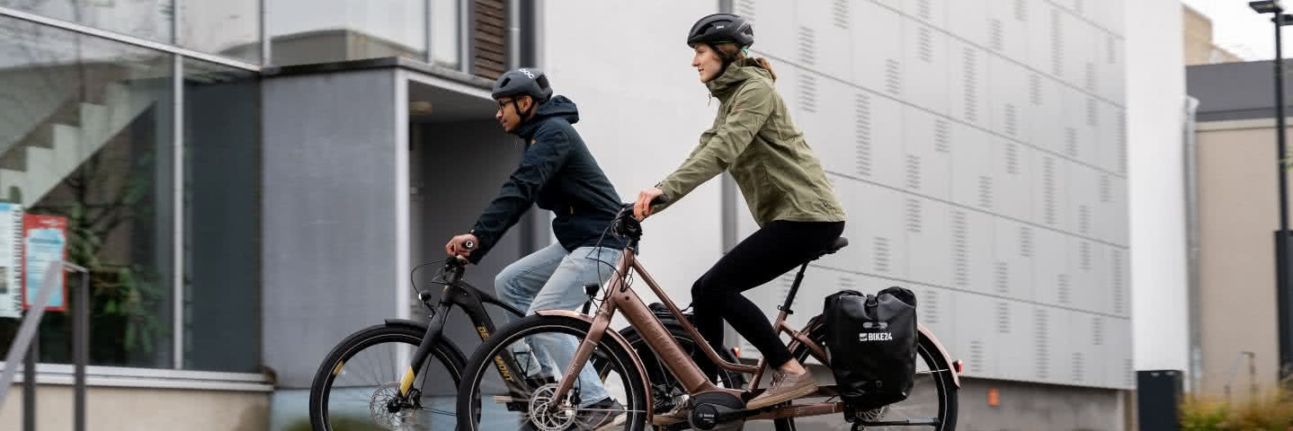 Man and woman cycling on city bikes