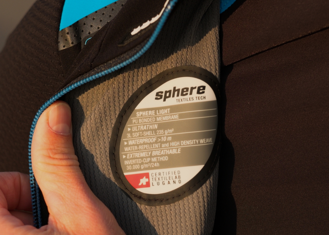 A person shows the spec label of a road bike jacket.