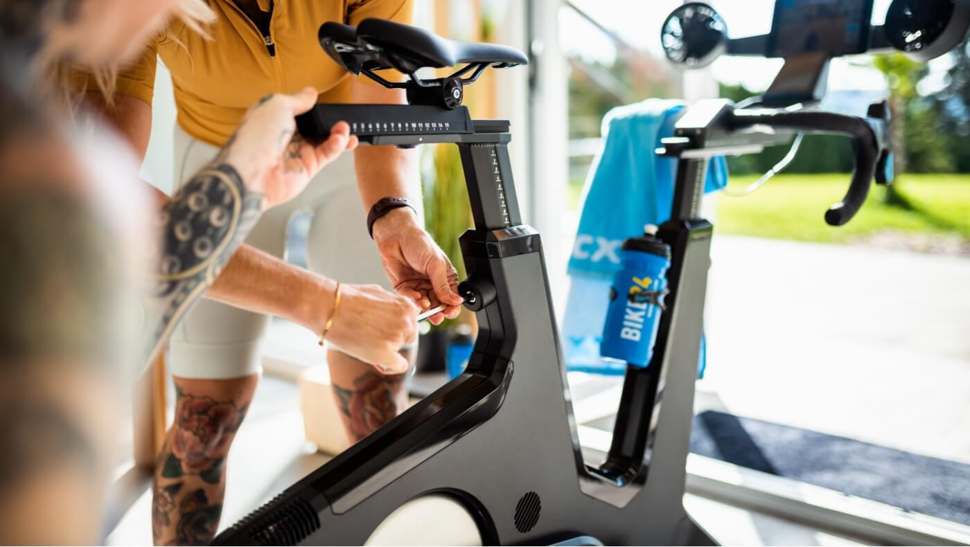Mujer montando en bicicleta en el salón de su casa
