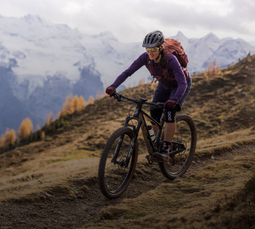 Eine Frau fährt mit dem Mountainbike durch die Berge.