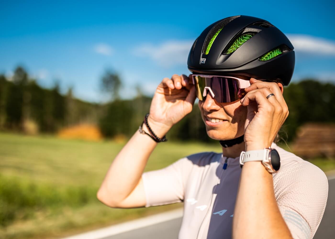 A woman is putting on road cycling sunglasses.