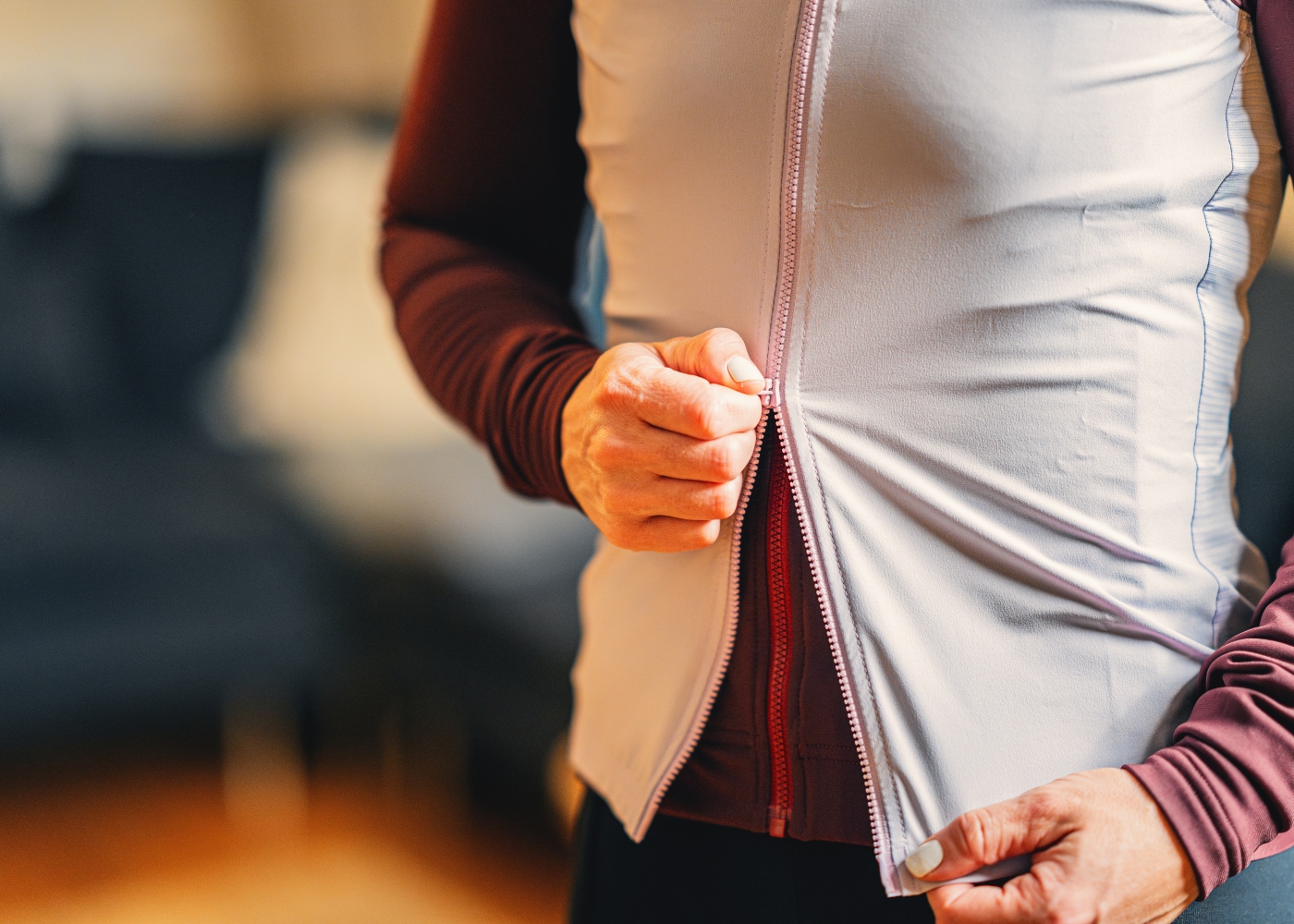 Close-up of a woman using a two-way zipper on her versatile road bike clothing.