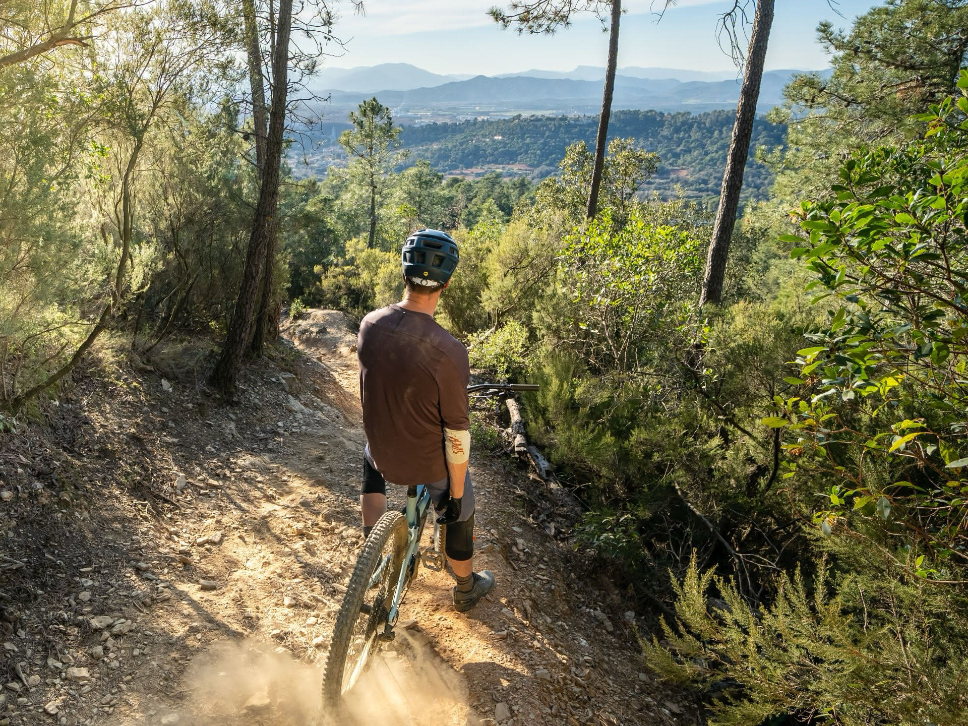 Ein Mountainbiker checkt den Gebirgs-Trail vor der Abfahrt.