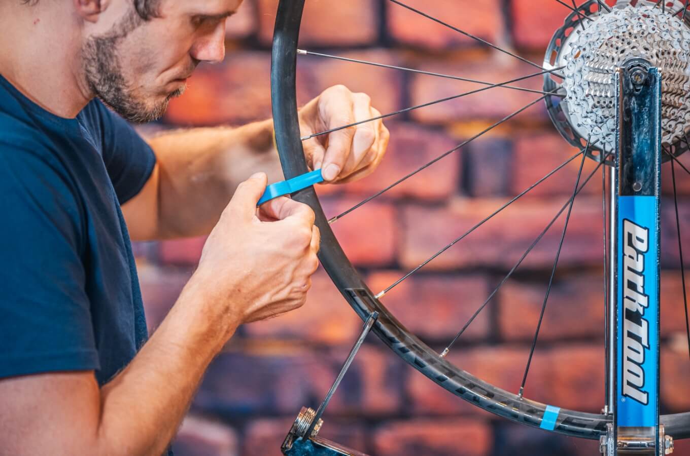 Close-up van een man die een fietswiel centreert