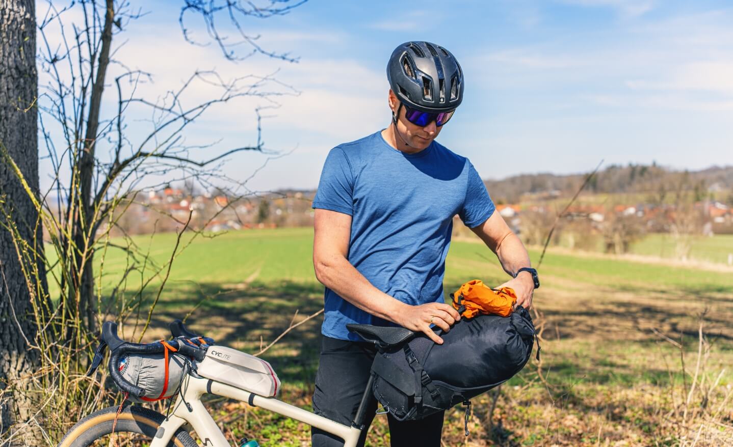 Ein Mann holt etwas aus seiner Bikepacking Satteltasche.