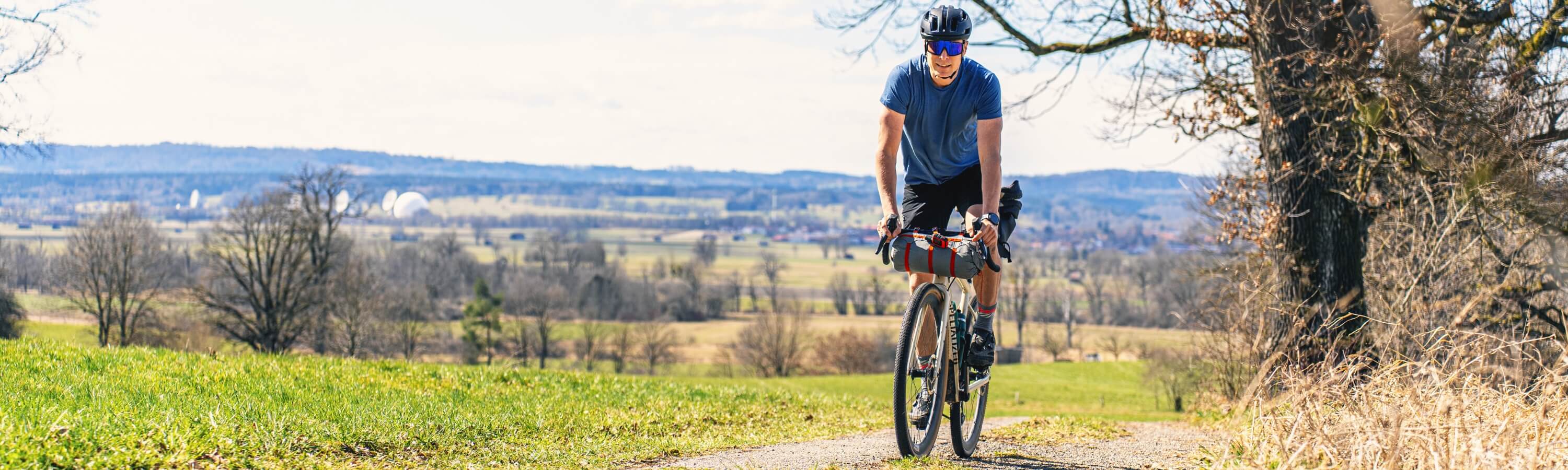 Mann auf seinem Bikepacking Rad vor einer Landschaft.