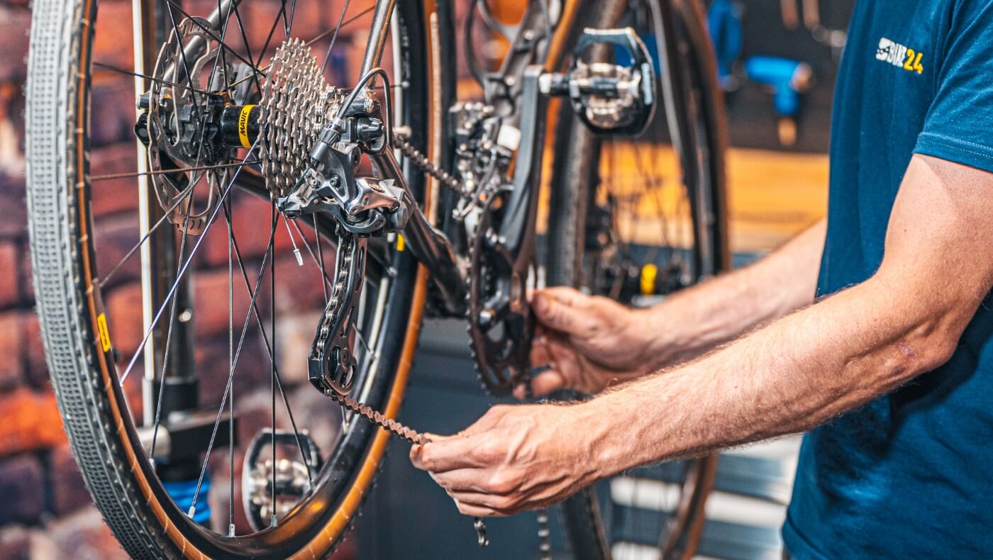Close-up van een persoon die een fietsketting verwisselt.