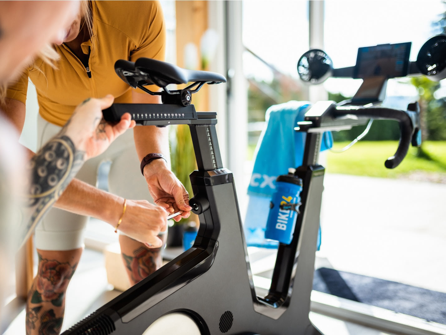 Two persons are setting up their new indoor bike. Two persons are setting up their new indoor bike.