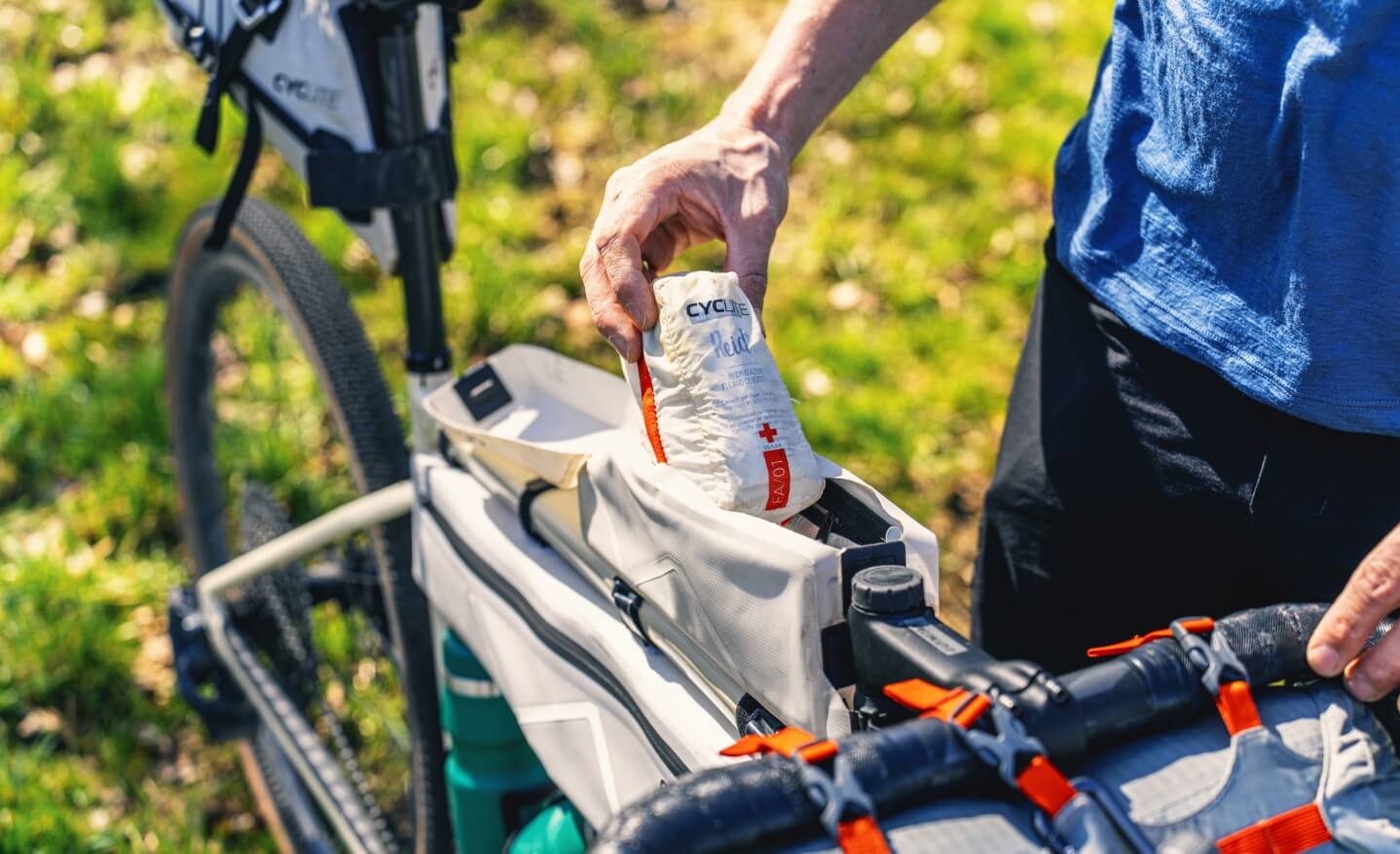 Eine Person nimmt etwas aus einer Bikepacking Oberrohrtasche.