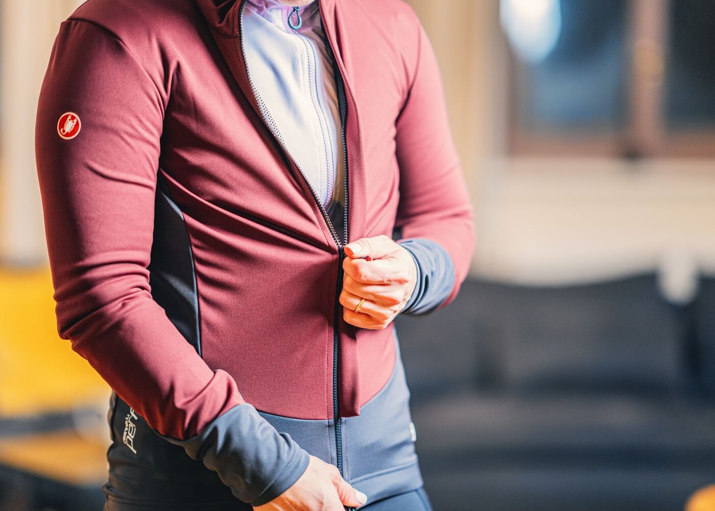 Close-up of a person zipping up a winter road bike jersey.